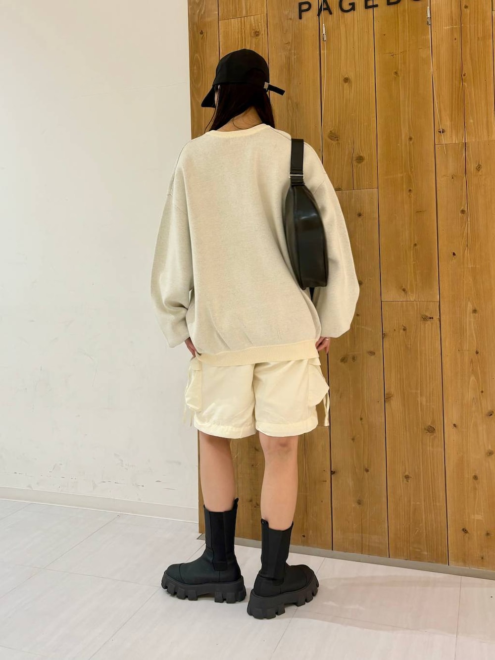 ホワイト系のカーゴパンツ、ブラック系のブーツ、ブラック系のショルダーバッグを着用したレディースの冬コーディネートの4枚目の写真