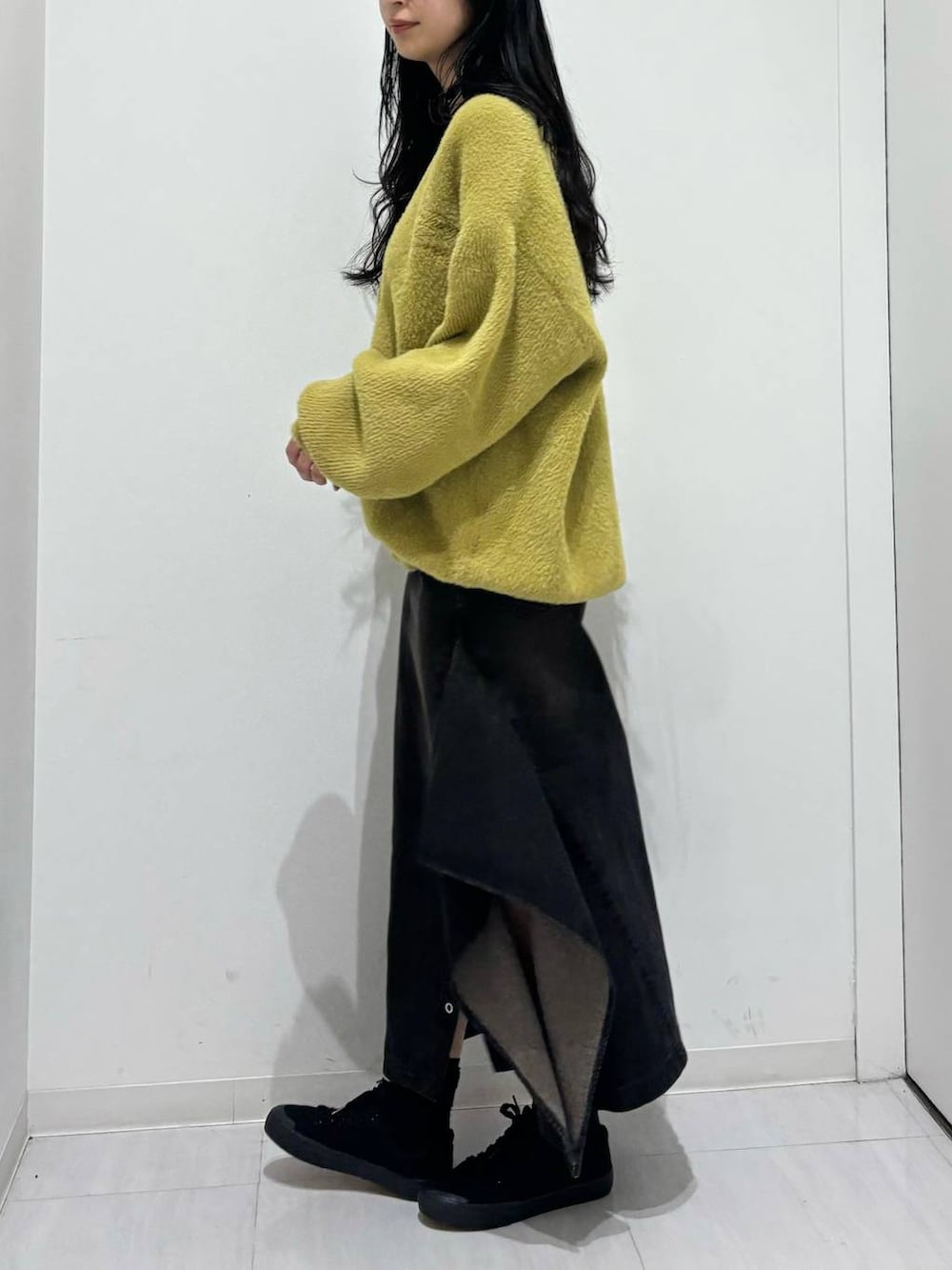 ブラック系のデニムスカート、イエロー系のカーディガン/ボレロを着用したレディースの秋コーディネートの3枚目の写真