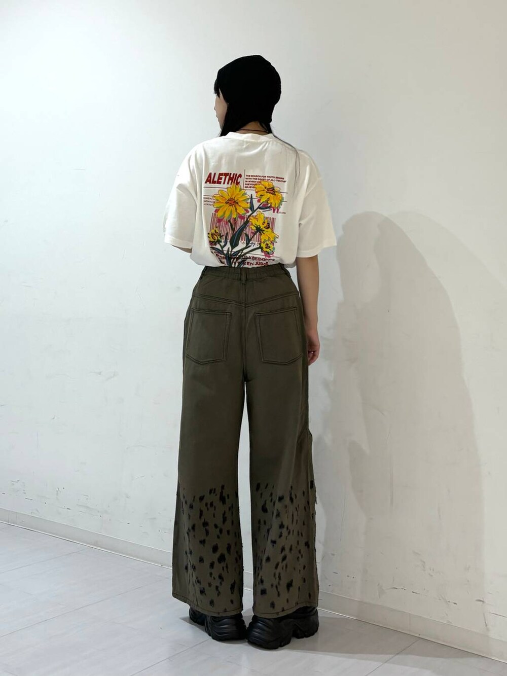 ブラック系のスニーカー、ホワイト系のTシャツ/カットソー、ブラック系のデニムパンツを着用したレディースの夏コーディネートの6枚目の写真