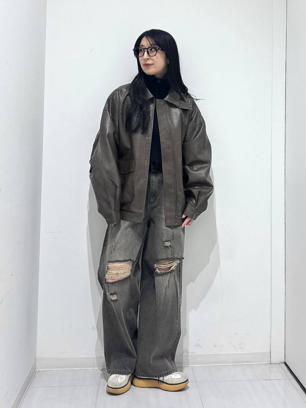 ブラウン系のブルゾン、ブラック系のデニムパンツ、ブラック系のニット/セーターを着用したレディースの秋コーディネートの6枚目の写真