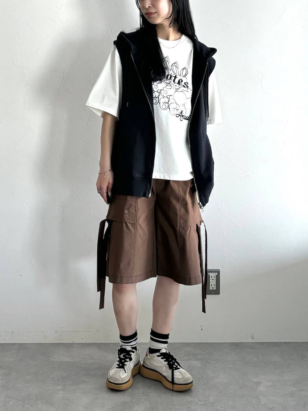 ブラック系のパーカー、ホワイト系のTシャツ/カットソー、ブラウン系のカーゴパンツを着用したレディースの夏コーディネートの5枚目の写真