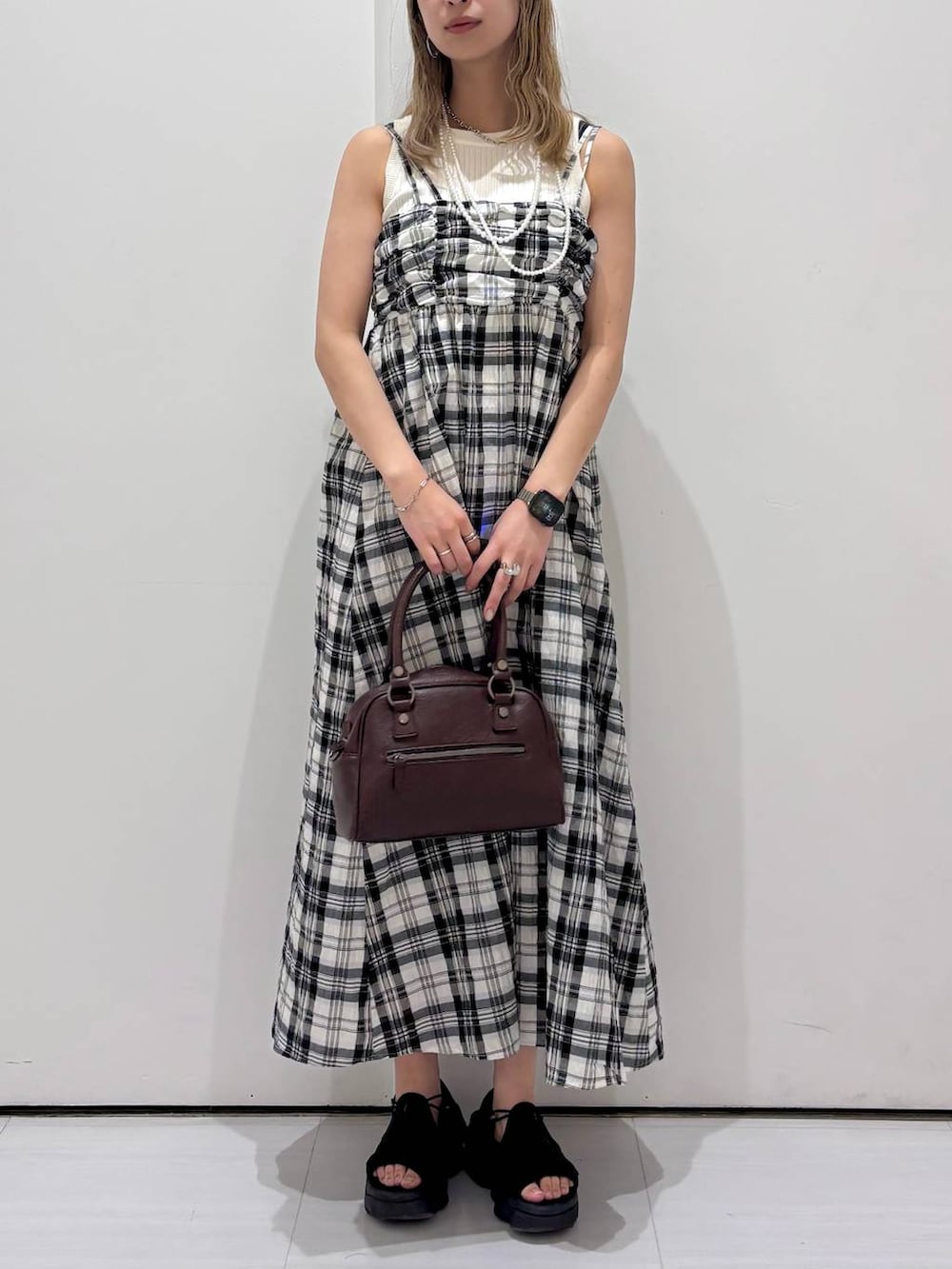 ホワイト系のタンクトップ、ブラウン系のショルダーバッグ、ホワイト系のワンピースを着用したレディースの夏コーディネートの3枚目の写真