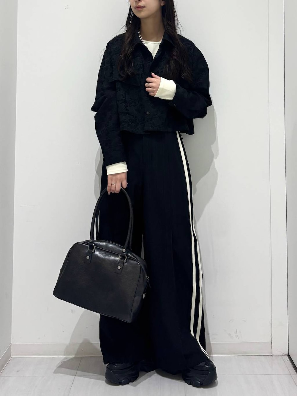 ブラック系のスニーカー、ブラック系のシャツ/ブラウス、グレー系のTシャツ/カットソーを着用したレディースの冬コーディネートの2枚目の写真