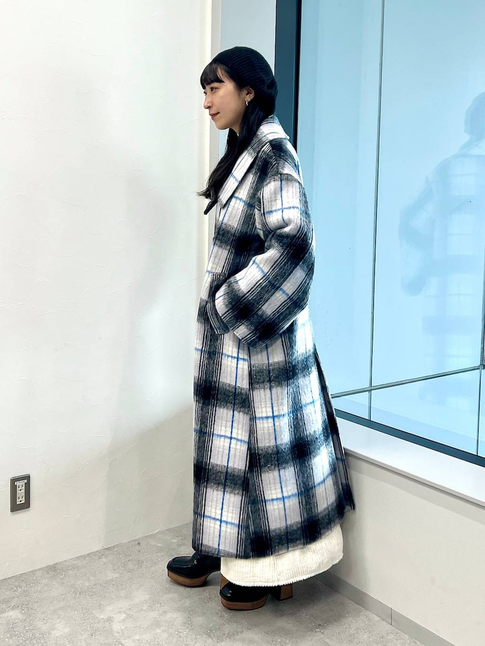 ホワイト系のステンカラーコート、ホワイト系のワンピース、ホワイト系のニット/セーターを着用したレディースの秋コーディネートの3枚目の写真