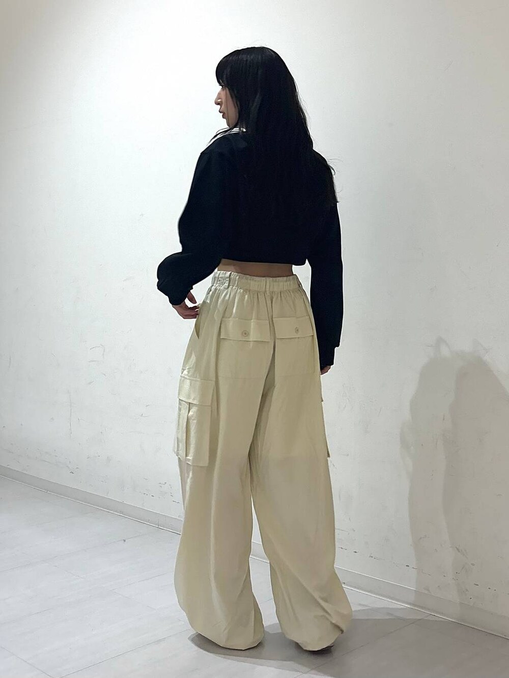 ホワイト系のカーゴパンツ、ブラック系のキャミソール、ブラック系のカーディガン/ボレロを着用したレディースの春コーディネートの3枚目の写真