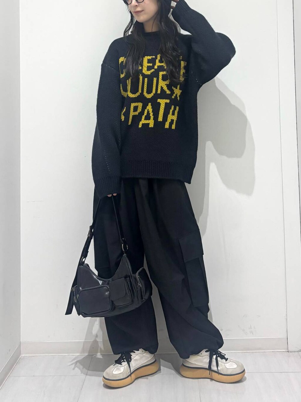 ブラック系のショルダーバッグ、ブラック系のカーゴパンツ、ブルー系のニット/セーターを着用したレディースの秋コーディネートの5枚目の写真