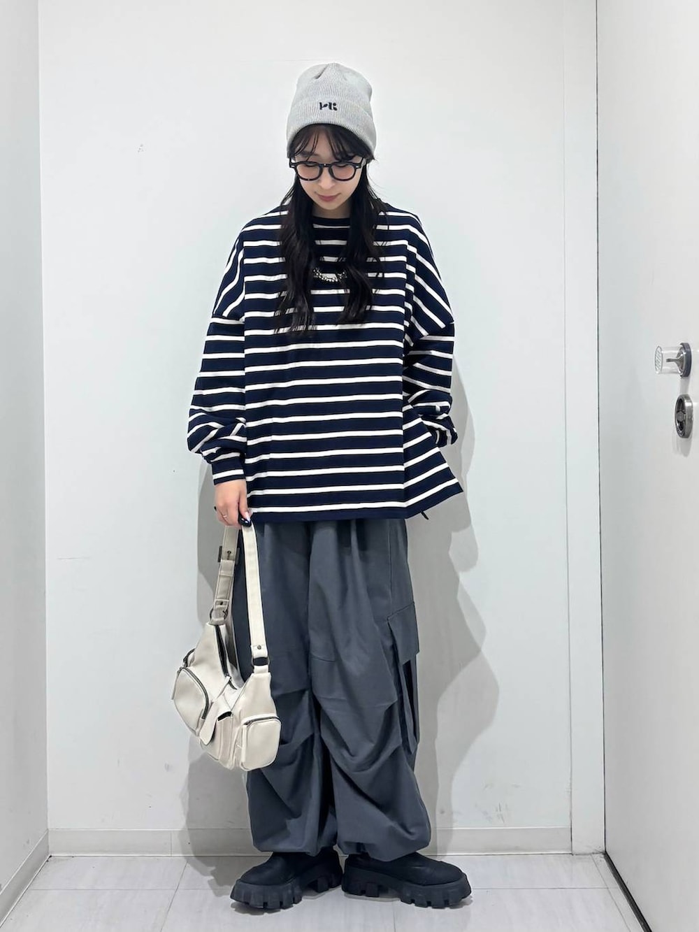 ホワイト系のショルダーバッグ、ブルー系のTシャツ/カットソー、グレー系のカーゴパンツを着用したレディースの冬コーディネートの5枚目の写真