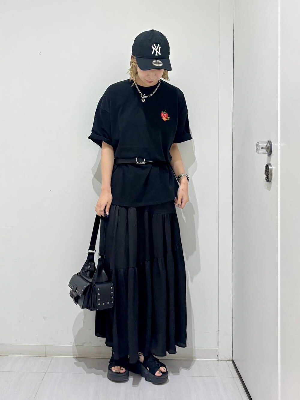 ブラック系のTシャツ/カットソー、ブラック系のスカート、ブラック系のショルダーバッグを着用したレディースの夏コーディネートの6枚目の写真