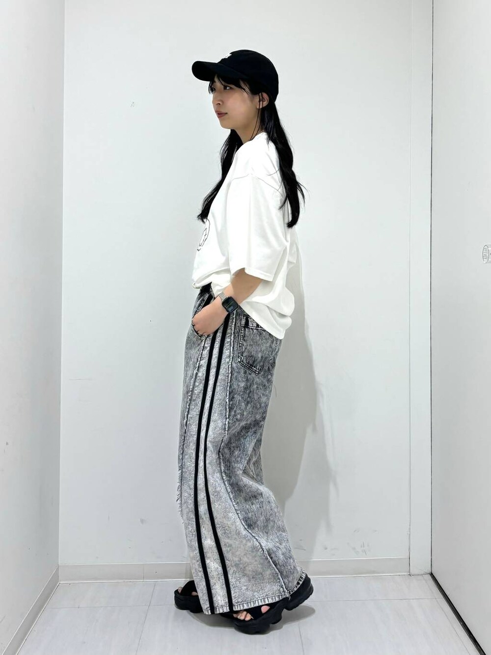 ホワイト系のTシャツ/カットソー、グレー系のデニムパンツ、ブラック系のキャップを着用したレディースの夏コーディネートの3枚目の写真