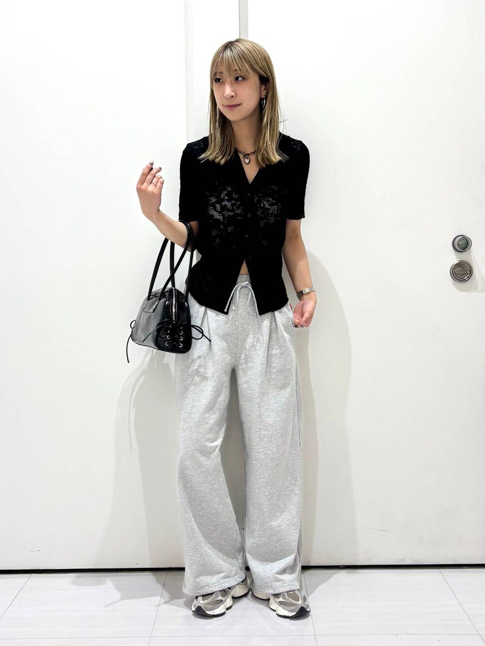 ブラック系のショルダーバッグ、ブラック系のシャツ/ブラウス、グレー系のスウェットパンツを着用したレディースの春コーディネートの9枚目の写真