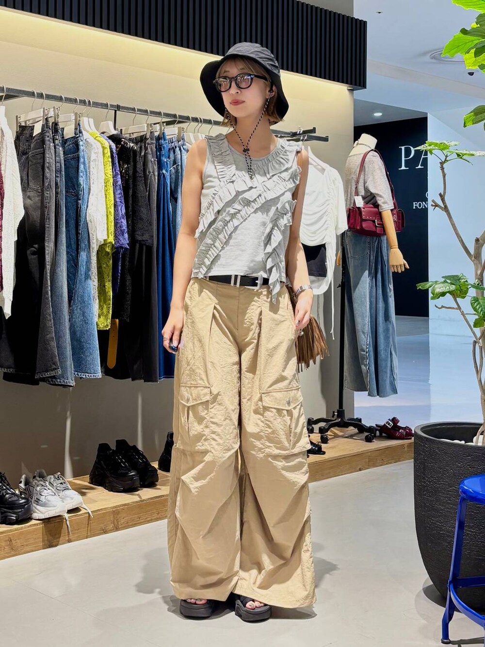 グレー系のタンクトップ、ベージュ系のカーゴパンツ、ブラック系のベルトを着用したレディースの夏コーディネートの3枚目の写真