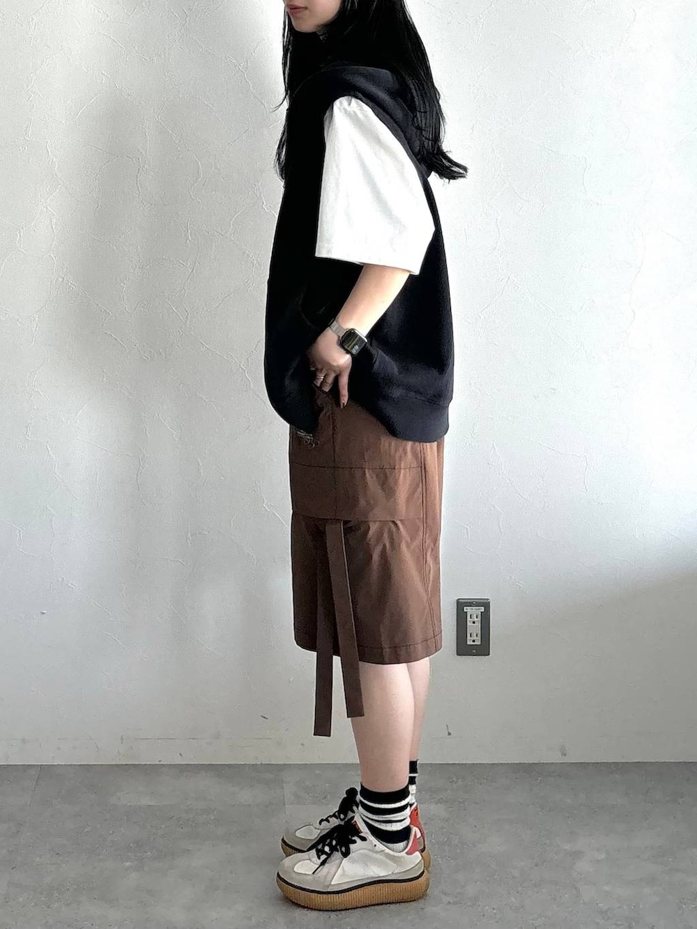 ブラック系のパーカー、ホワイト系のTシャツ/カットソー、ブラウン系のカーゴパンツを着用したレディースの夏コーディネートの3枚目の写真