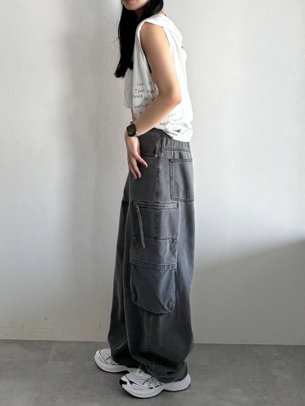 ブラック系のデニムパンツ、ホワイト系のTシャツ/カットソーを着用したレディースの春コーディネートの2枚目の写真