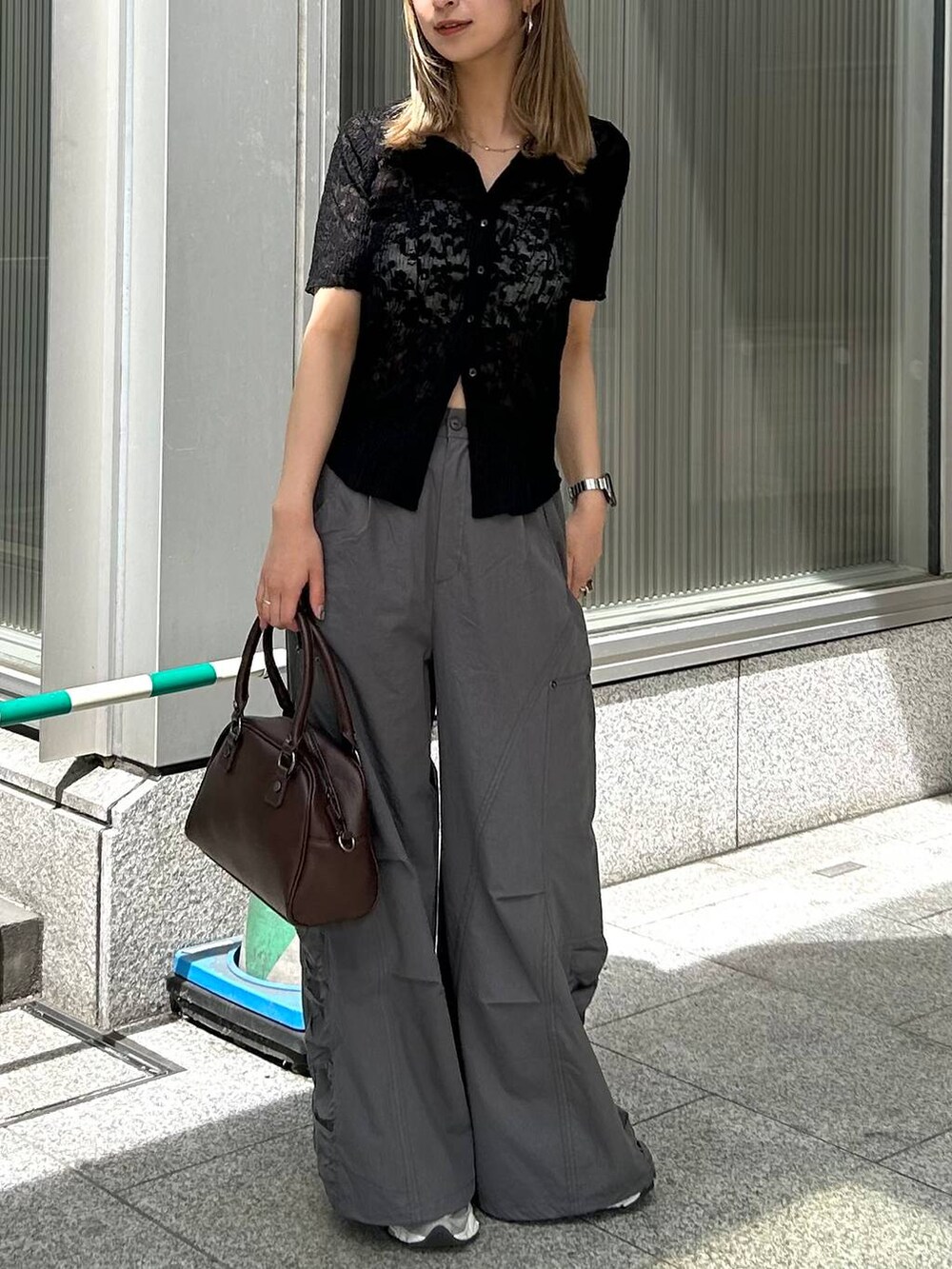 グレー系のカーゴパンツ、ブラウン系のショルダーバッグ、ブラック系のシャツ/ブラウスを着用したレディースの夏コーディネートの3枚目の写真
