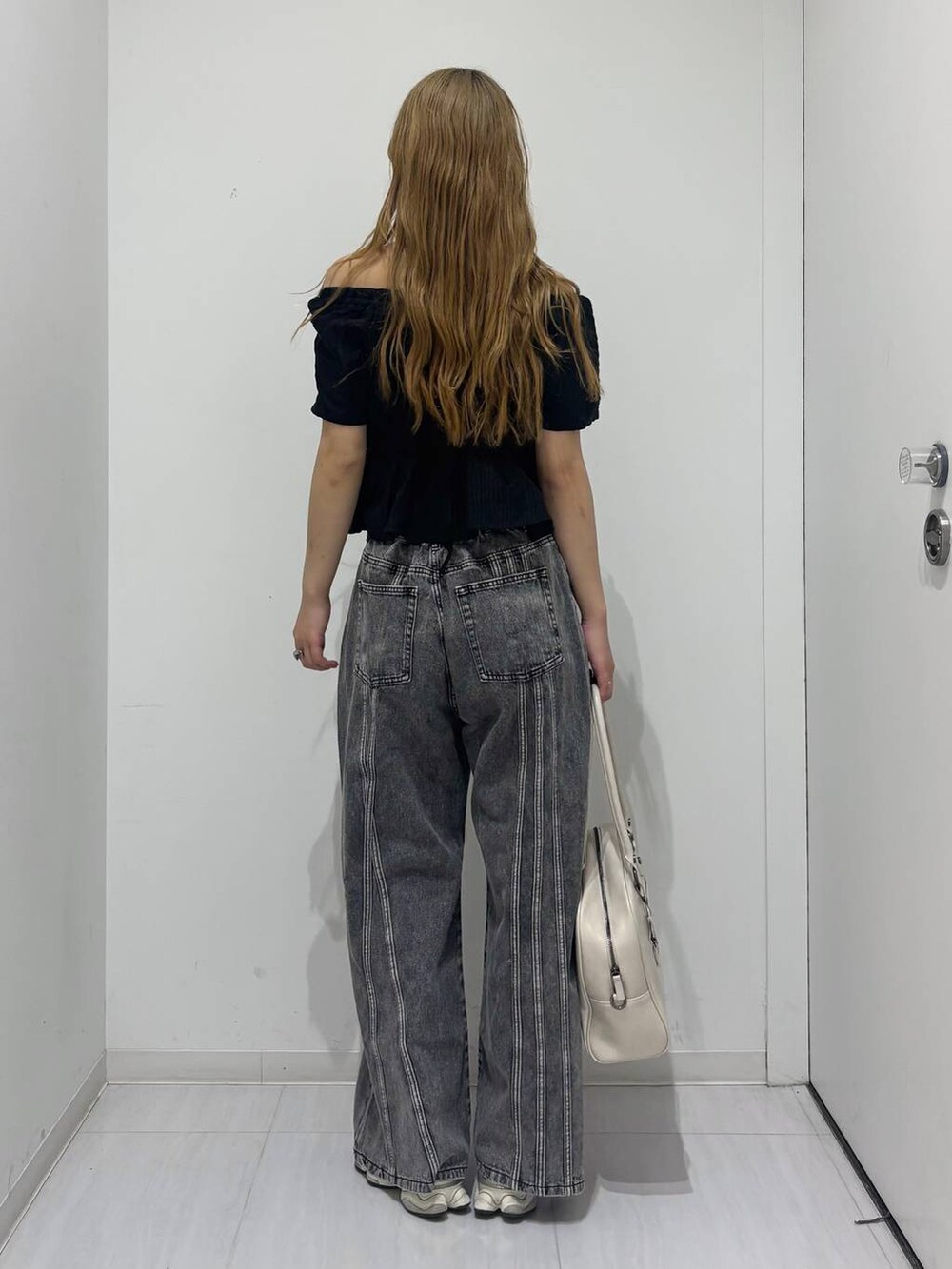 ホワイト系のボストンバッグ、ブラック系のデニムパンツ、ブラック系のシャツ/ブラウスを着用したレディースの春コーディネートの4枚目の写真