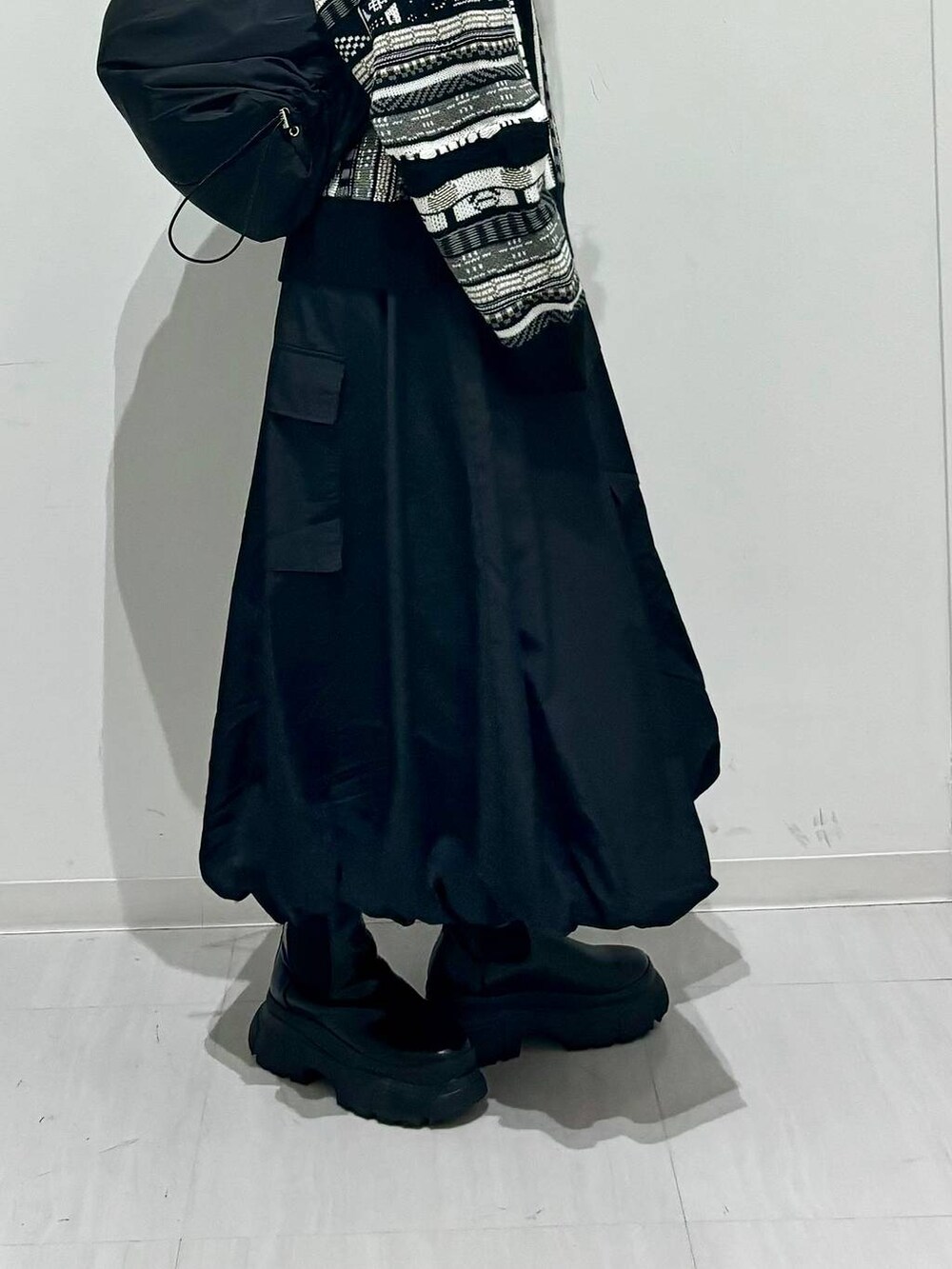 ブラック系のブーツ、ブラック系のショルダーバッグ、ブラック系のニット/セーターを着用したレディースの秋コーディネートの4枚目の写真