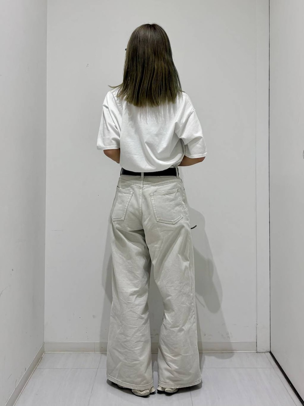 グレー系のデニムパンツ、ホワイト系のTシャツ/カットソー、シルバー系のショルダーバッグを着用したレディースの春コーディネートの3枚目の写真