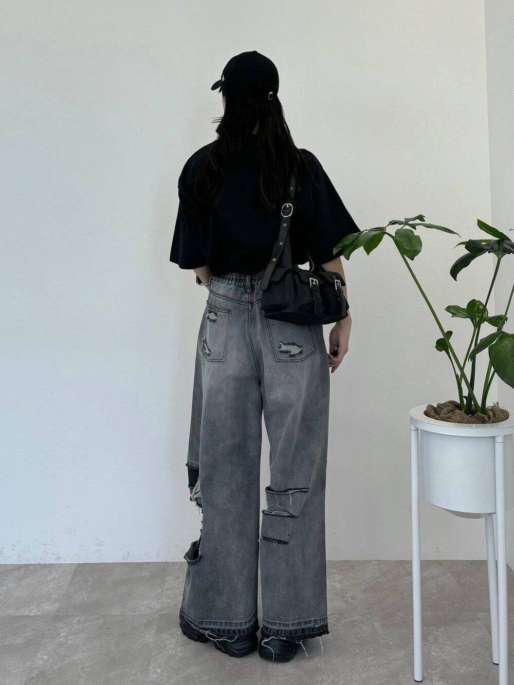 ブラック系のデニムパンツ、ブラック系のスニーカー、ブラック系のTシャツ/カットソーを着用したレディースの春コーディネートの5枚目の写真