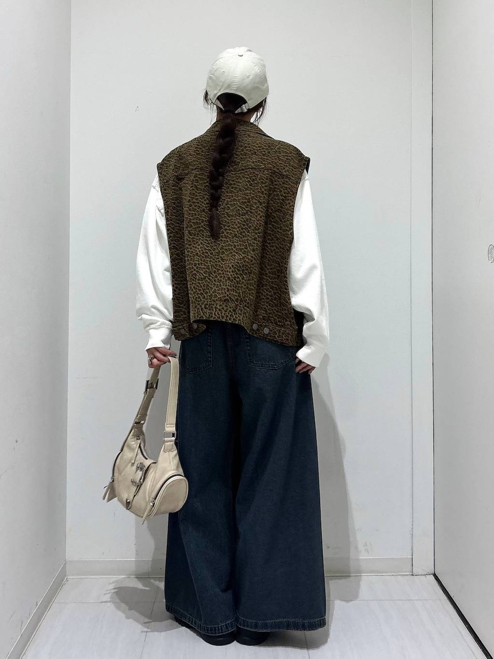 ブルー系のデニムパンツ、ホワイト系のスウェット、ブラック系のスニーカーを着用したレディースの春コーディネートの6枚目の写真