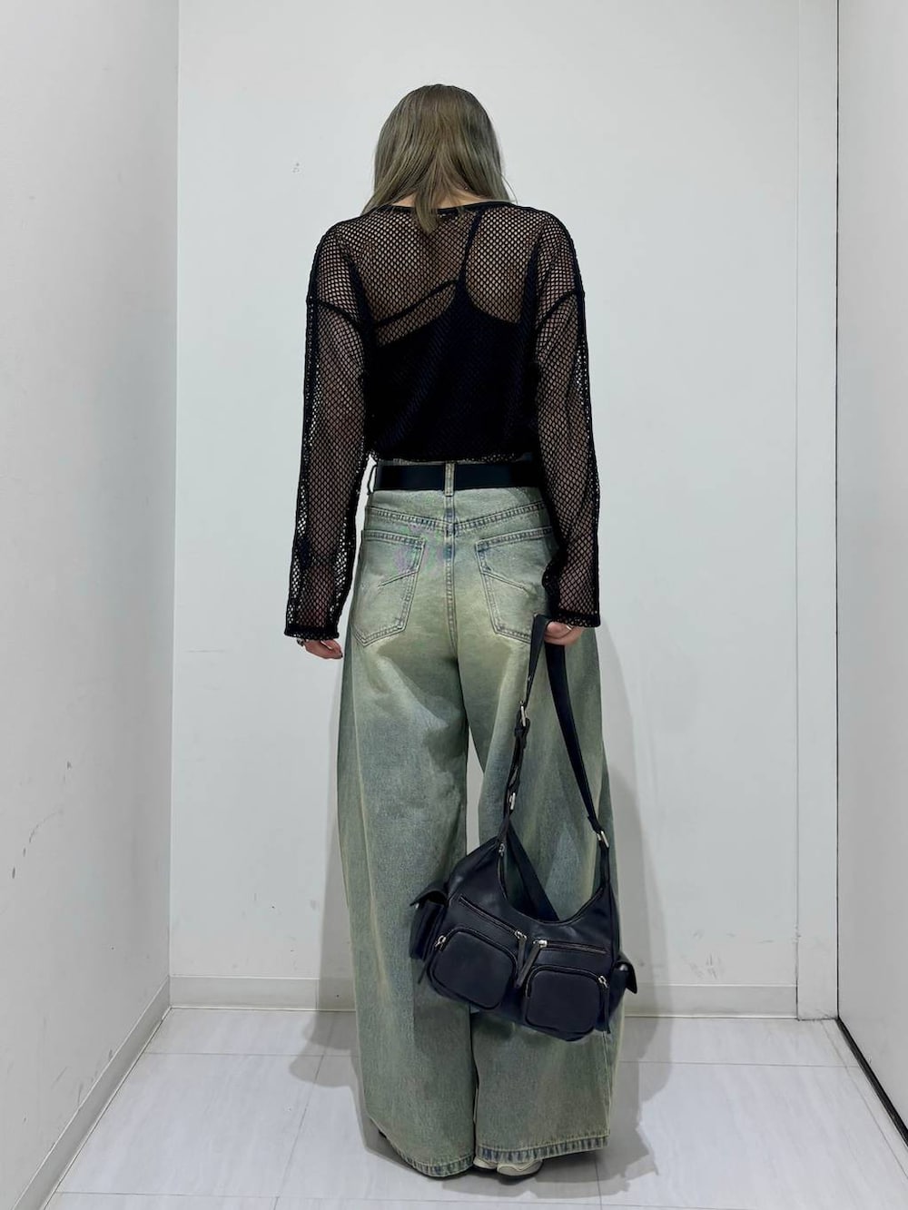 ブルー系のデニムパンツ、ブラック系のTシャツ/カットソー、ブラック系のショルダーバッグを着用したレディースの春コーディネートの4枚目の写真