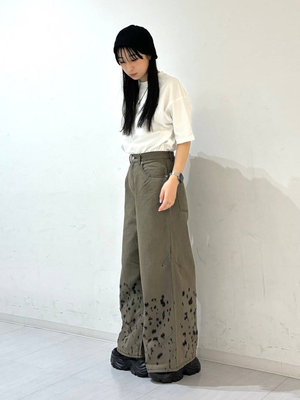 ブラック系のスニーカー、ホワイト系のTシャツ/カットソー、ブラック系のデニムパンツを着用したレディースの夏コーディネートの4枚目の写真