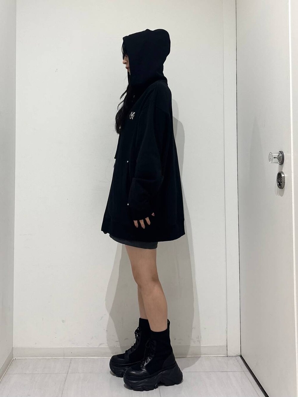 ブラック系のブーツ、ブラック系のパーカー、グレー系のその他パンツを着用したレディースの秋コーディネートの4枚目の写真