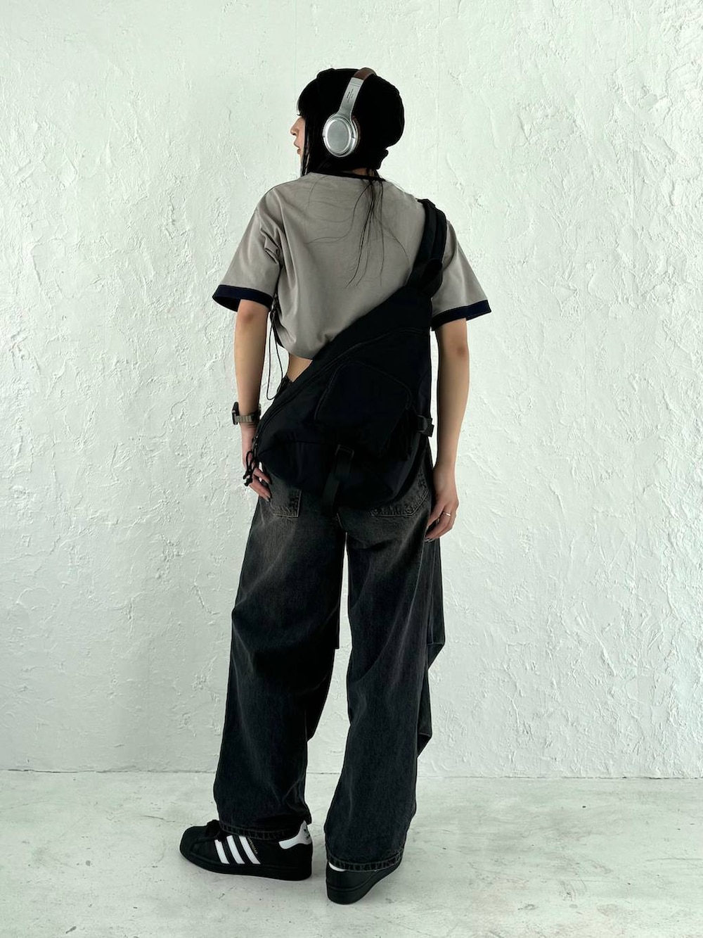 ブラック系のデニムパンツ、ブラック系のボディバッグ/ウエストポーチ、グレー系のTシャツ/カットソーを着用したレディースの春コーディネートの3枚目の写真