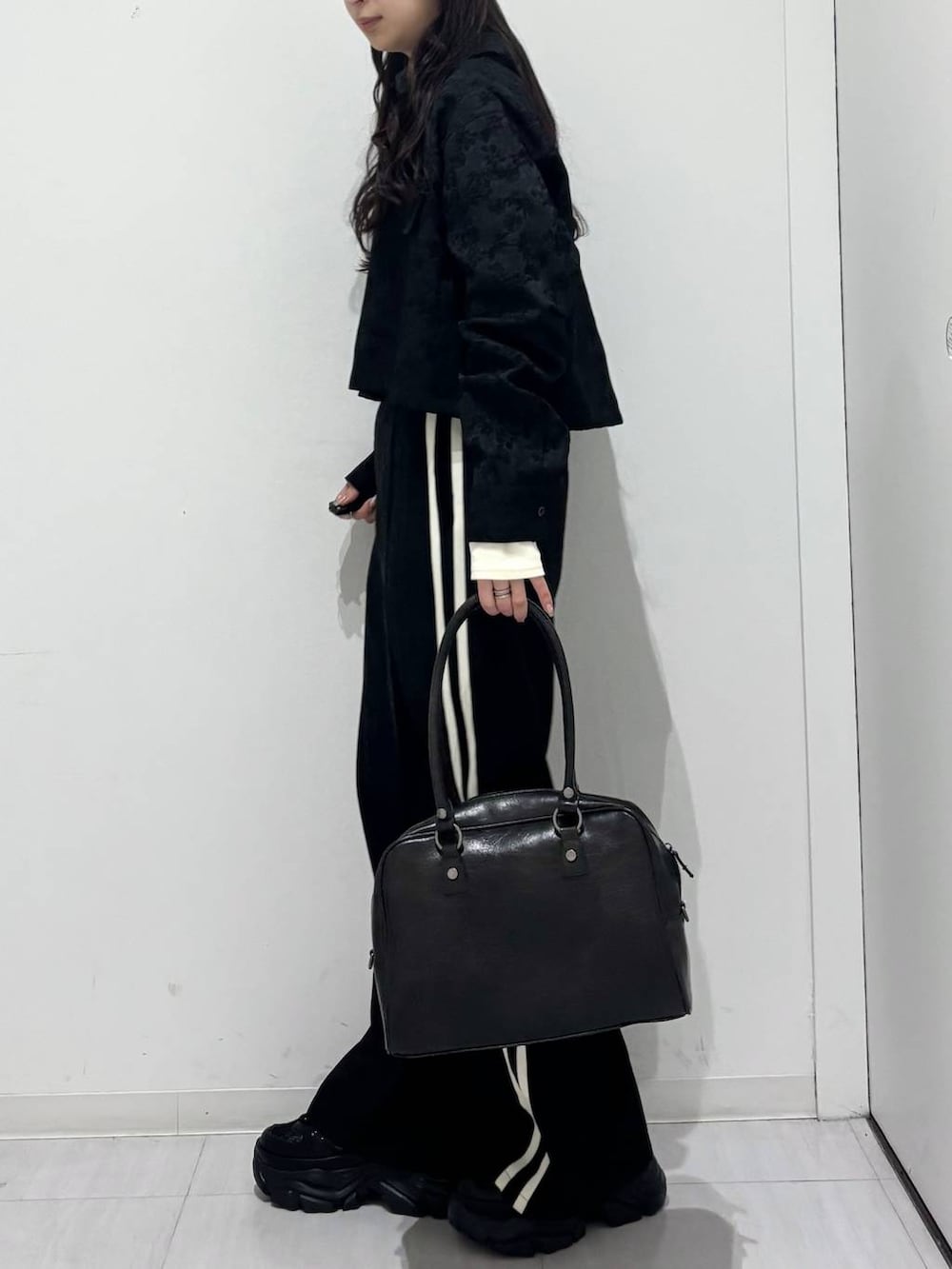 ブラック系のスニーカー、ブラック系のシャツ/ブラウス、グレー系のTシャツ/カットソーを着用したレディースの冬コーディネートの3枚目の写真