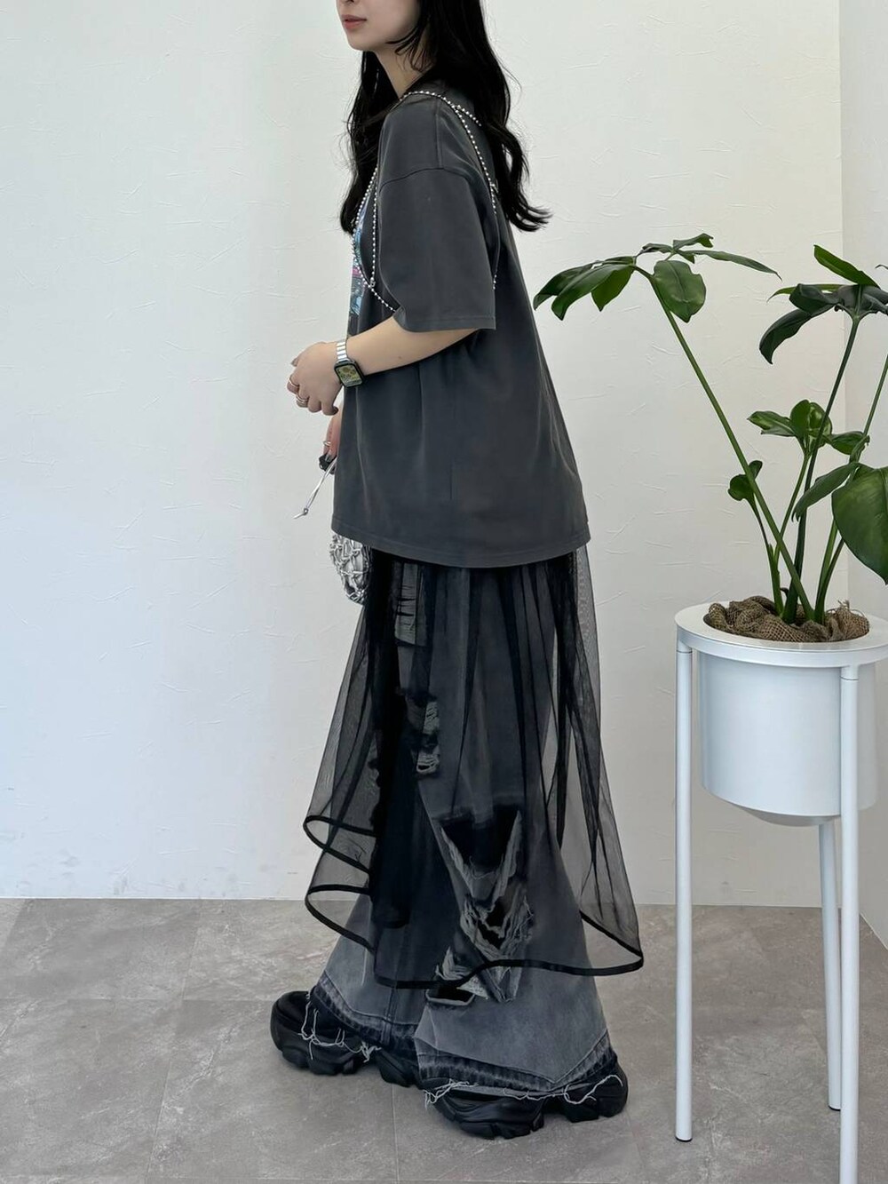 ブラック系のデニムパンツ、グレー系のTシャツ/カットソー、シルバー系のショルダーバッグを着用したレディースの春コーディネートの4枚目の写真