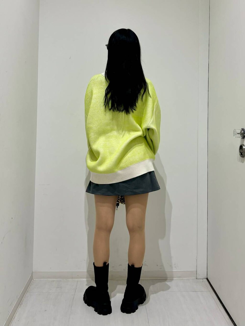 ブラック系のブーツ、ホワイト系のニット/セーター、ゴールド系のショルダーバッグを着用したレディースの冬コーディネートの4枚目の写真