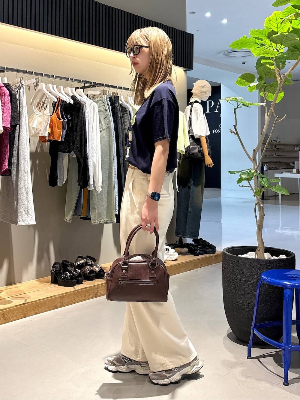 ブルー系のTシャツ/カットソー、ブラウン系のショルダーバッグ、ホワイト系のスウェットパンツを着用したレディースの夏コーディネートの4枚目の写真