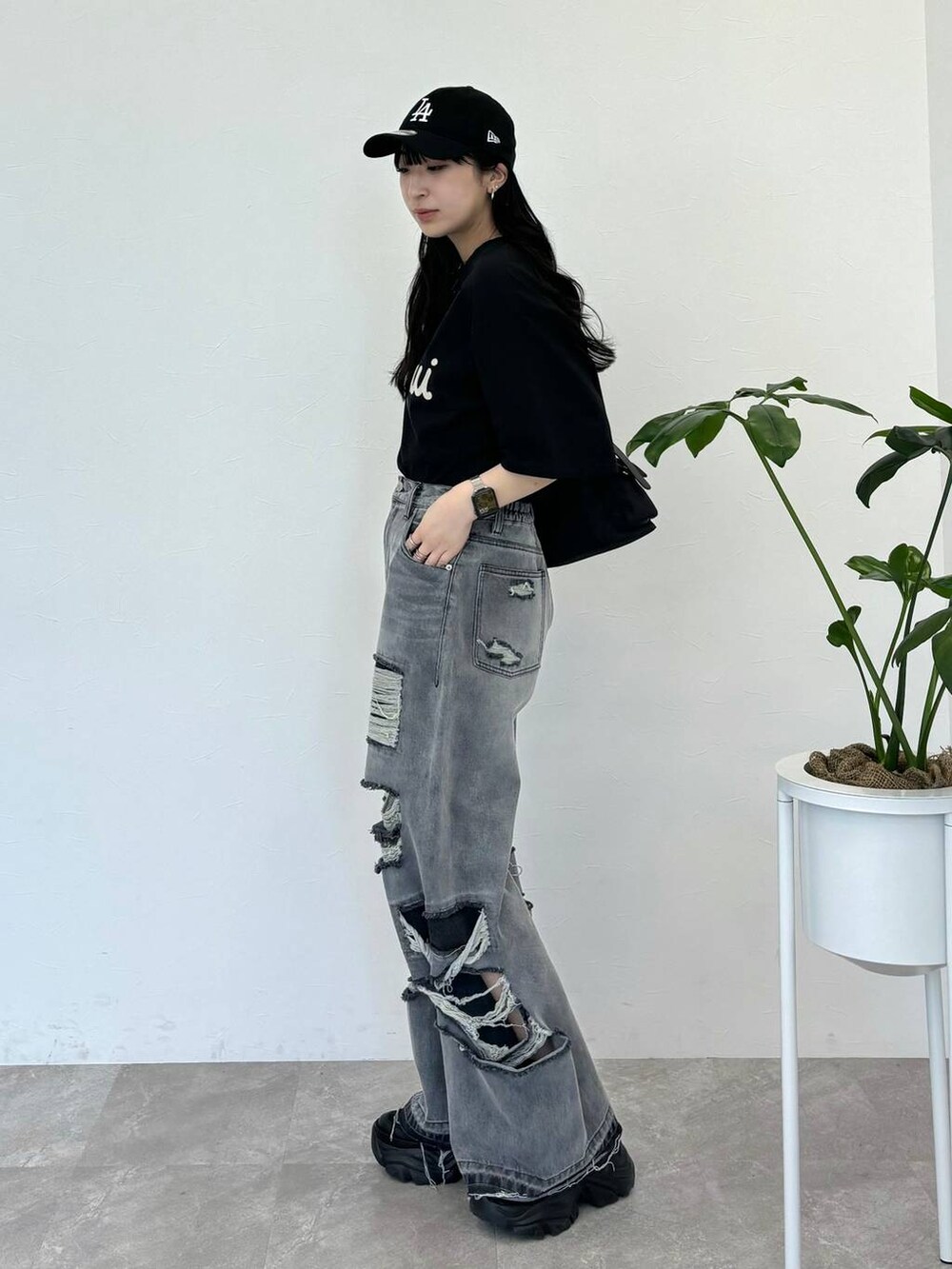 ブラック系のデニムパンツ、ブラック系のスニーカー、ブラック系のTシャツ/カットソーを着用したレディースの春コーディネートの3枚目の写真
