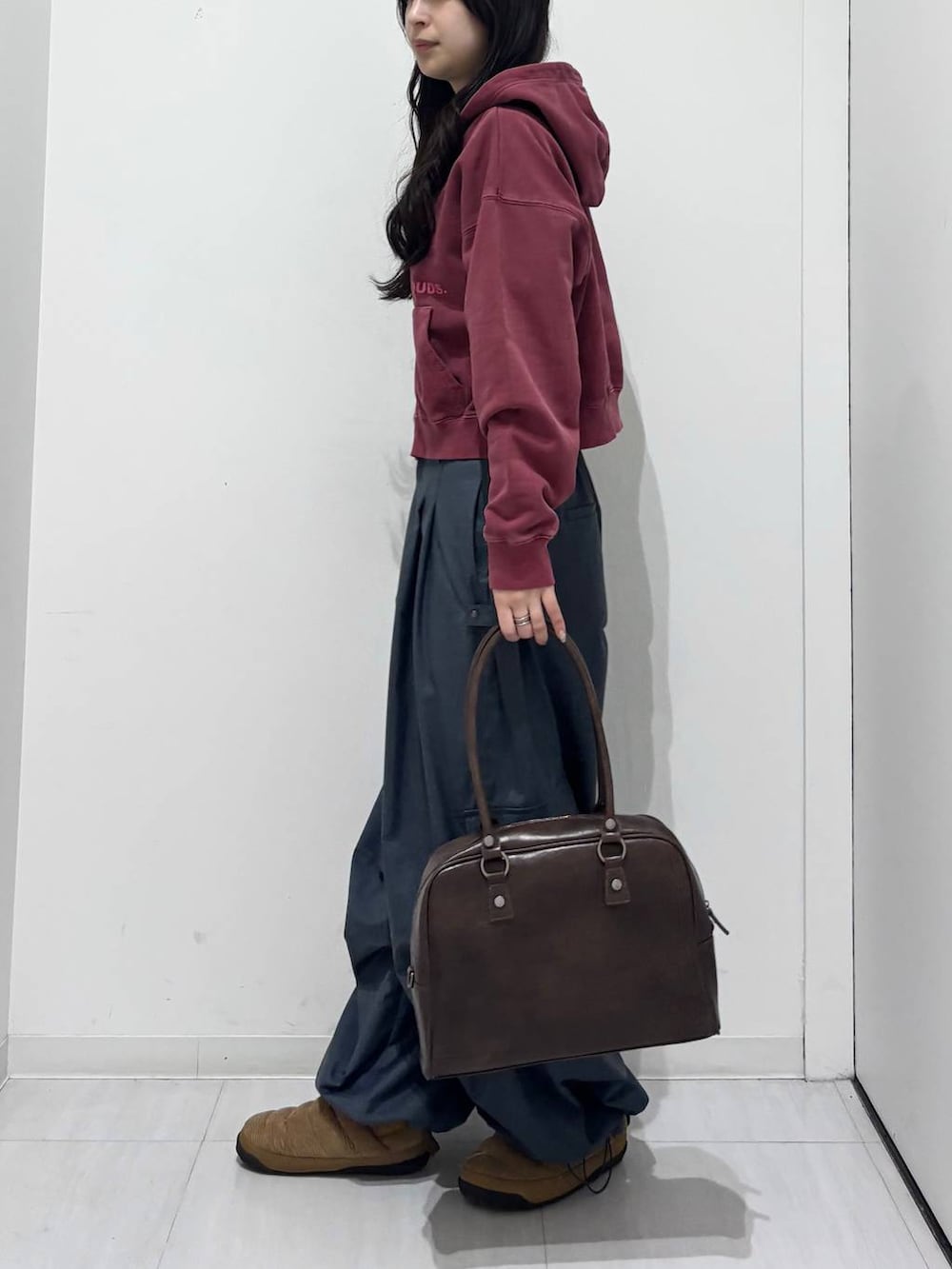 グレー系のカーゴパンツ、ブラウン系のボストンバッグ、レッド系のスウェットを着用したレディースの冬コーディネートの3枚目の写真