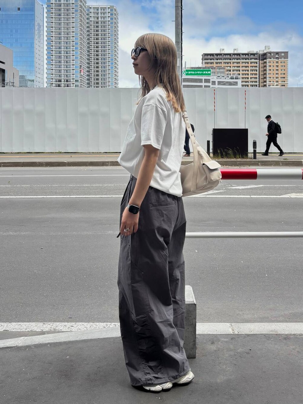ホワイト系のショルダーバッグ、ホワイト系のTシャツ/カットソー、グレー系のカーゴパンツを着用したレディースの夏コーディネートの4枚目の写真