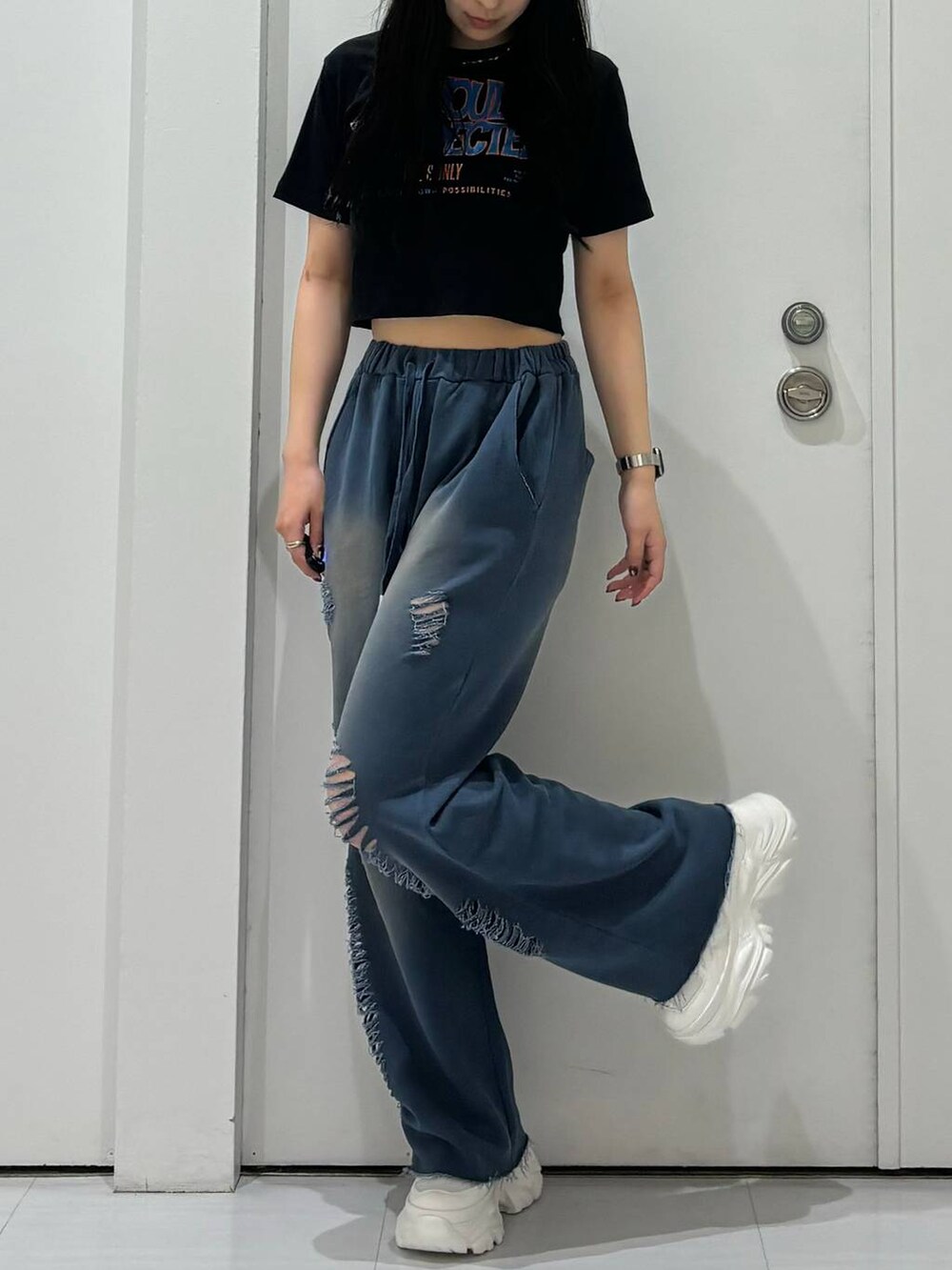 ホワイト系のスニーカー、ブルー系のスウェットパンツを着用したレディースの夏コーディネートの3枚目の写真