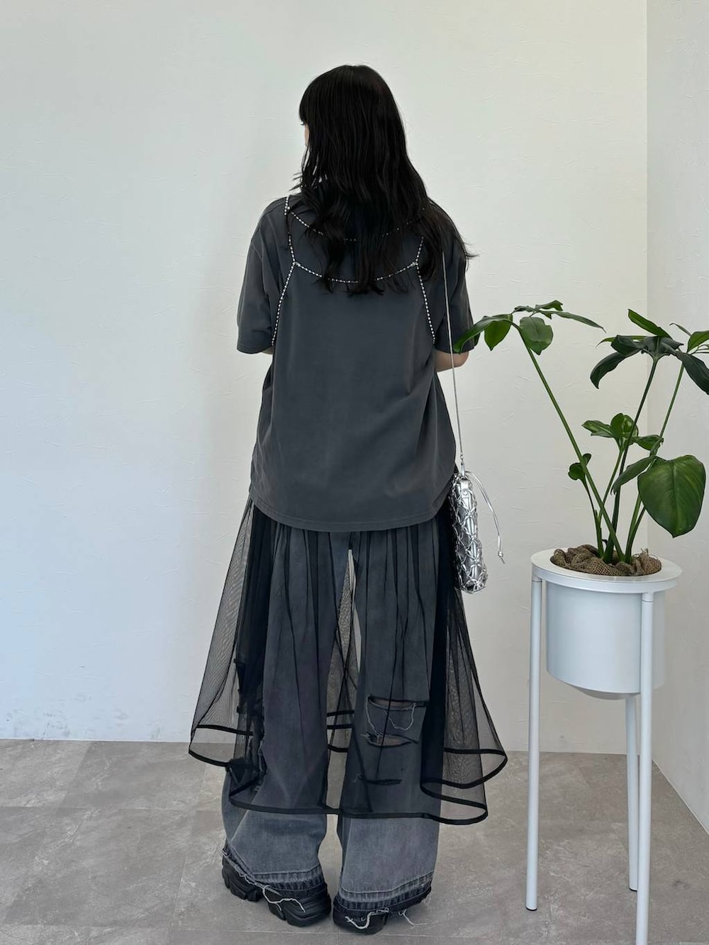 ブラック系のデニムパンツ、グレー系のTシャツ/カットソー、シルバー系のショルダーバッグを着用したレディースの春コーディネートの5枚目の写真