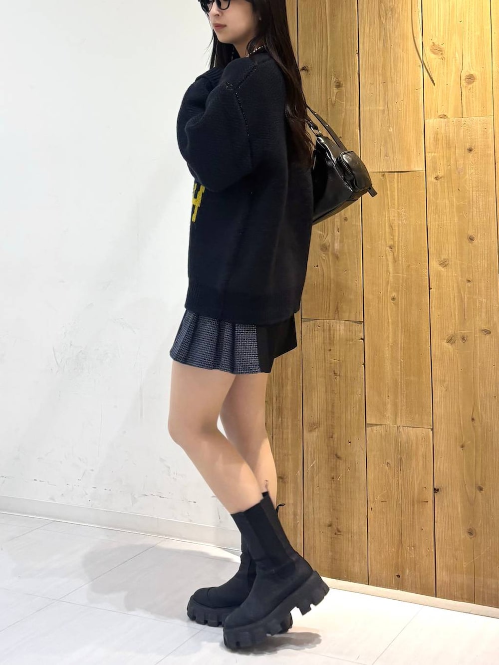 ブラック系のショルダーバッグ、ブラック系のその他パンツ、ブルー系のニット/セーターを着用したレディースの冬コーディネートの3枚目の写真