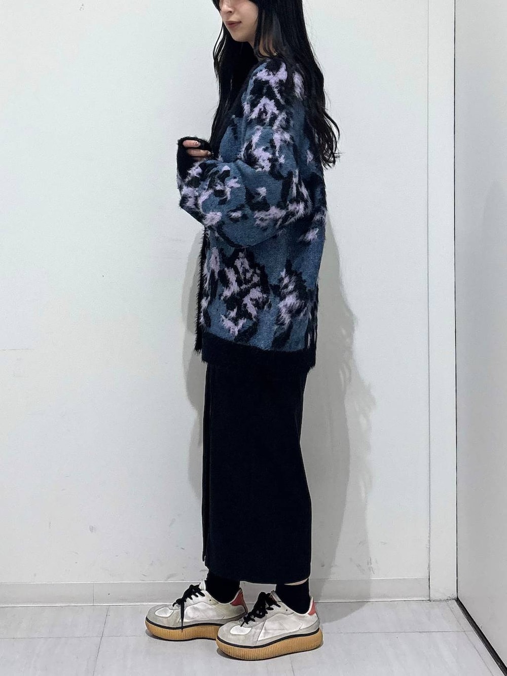 ブルー系のニット/セーター、ホワイト系のTシャツ/カットソー、ブラック系のワンピースを着用したレディースの秋コーディネートの2枚目の写真