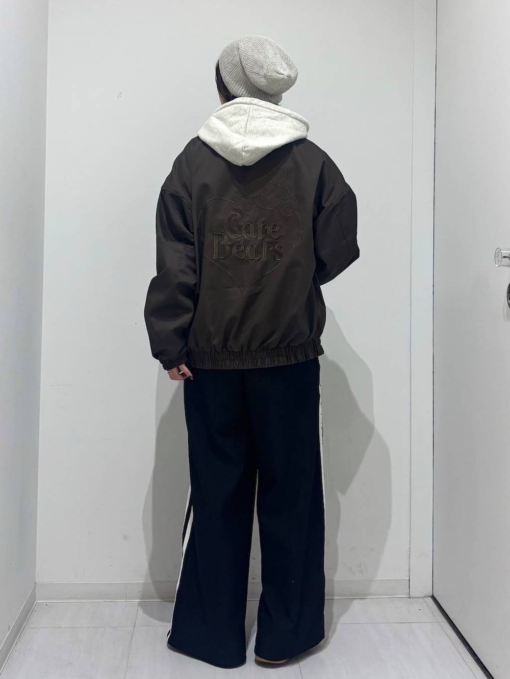 ベージュ系のショルダーバッグ、ブラック系のスラックス、ベージュ系のパーカーを着用したレディースの春コーディネートの4枚目の写真