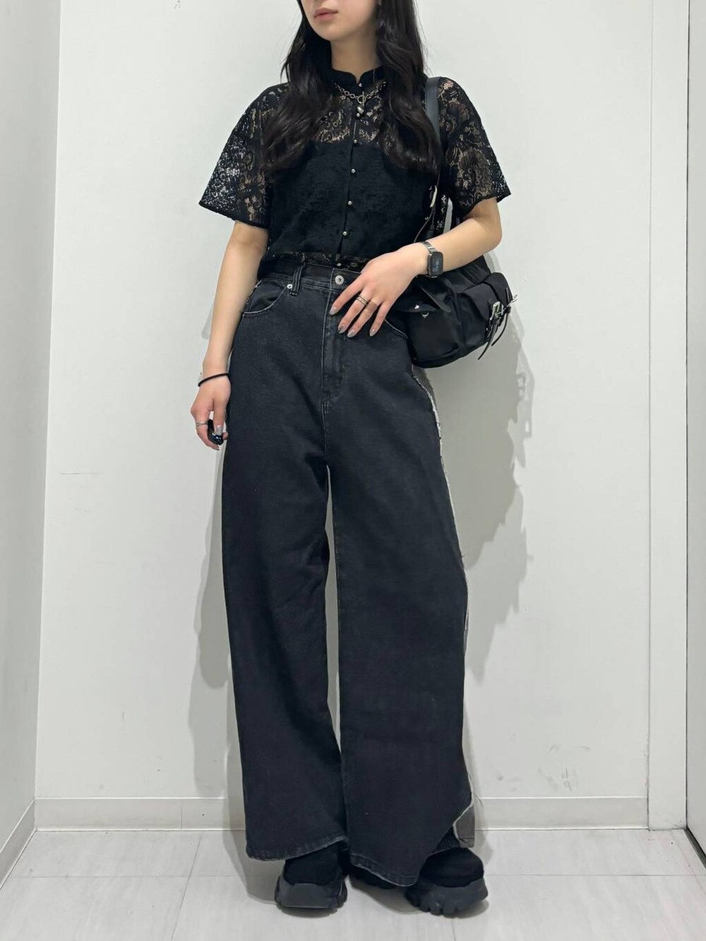 ブラック系のショルダーバッグ、ブラック系のシャツ/ブラウス、ブラック系のデニムパンツを着用したレディースの春コーディネートの2枚目の写真