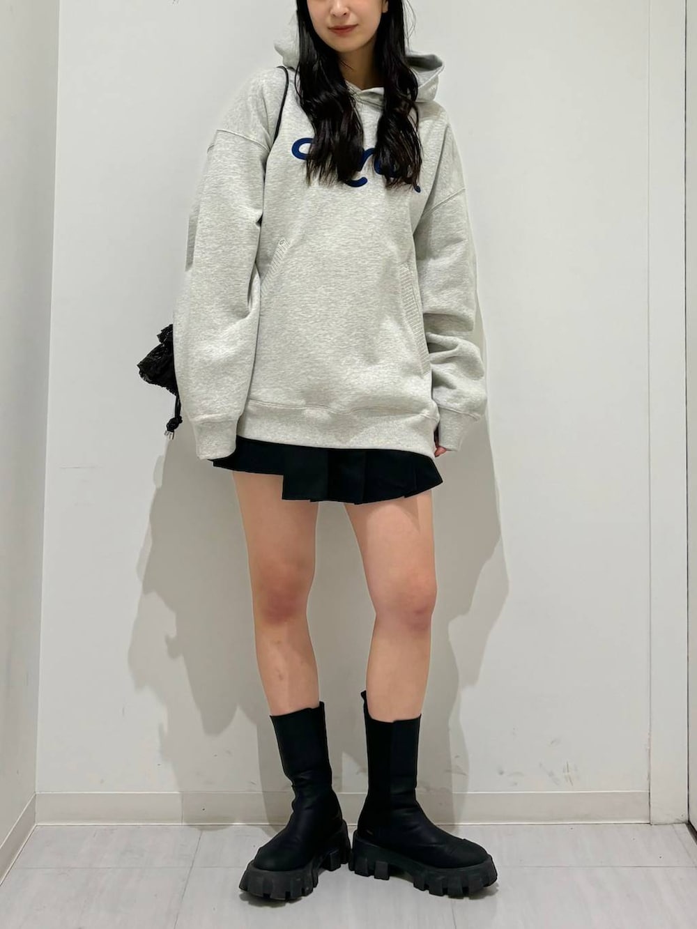 グレー系のパーカー、ブラック系のブーツ、ブラック系のその他パンツを着用したレディースの冬コーディネートの6枚目の写真