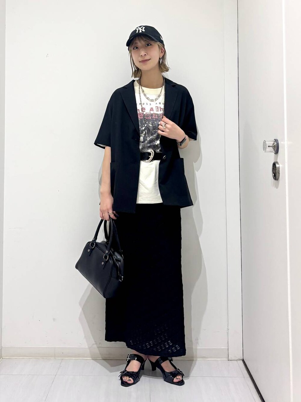 ブラック系のサンダル、ブラック系のショルダーバッグ、ブラック系のテーラードジャケットを着用したレディースの夏コーディネートの4枚目の写真