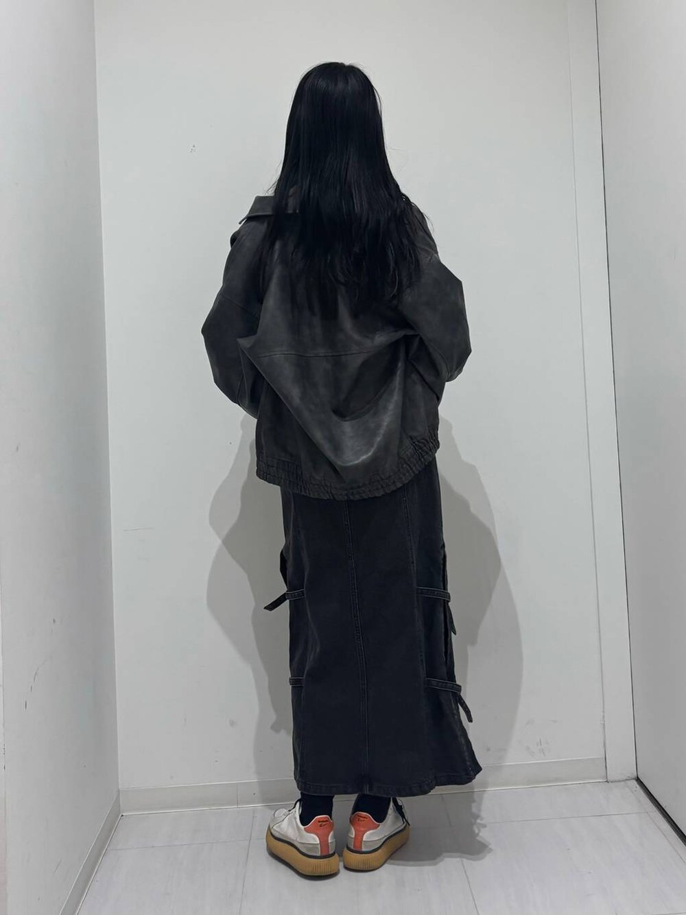 ブラック系のブルゾン、ブラック系のデニムスカート、ブラック系のニット/セーターを着用したレディースの秋コーディネートの3枚目の写真