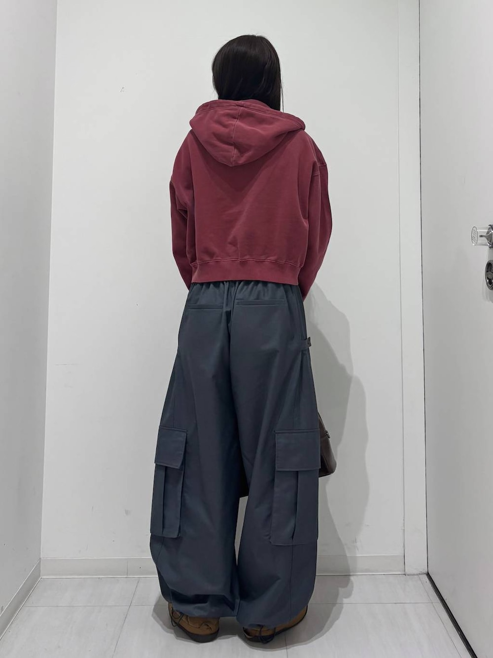 グレー系のカーゴパンツ、ブラウン系のボストンバッグ、レッド系のスウェットを着用したレディースの冬コーディネートの4枚目の写真