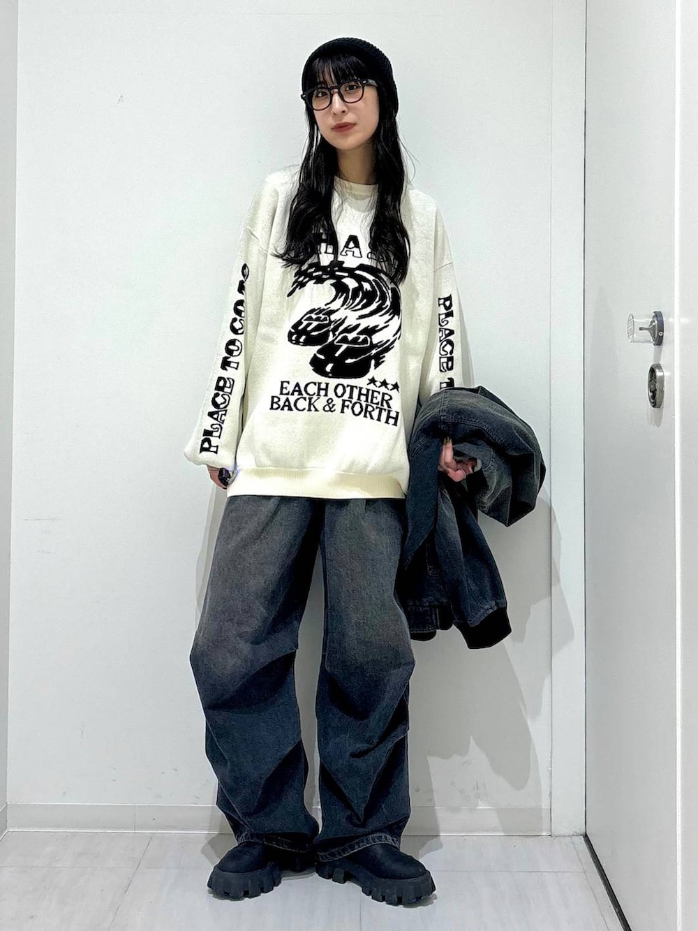 ホワイト系のニット/セーター、ブラック系のデニムジャケット、ブラック系のブーツを着用したレディースの冬コーディネートの8枚目の写真