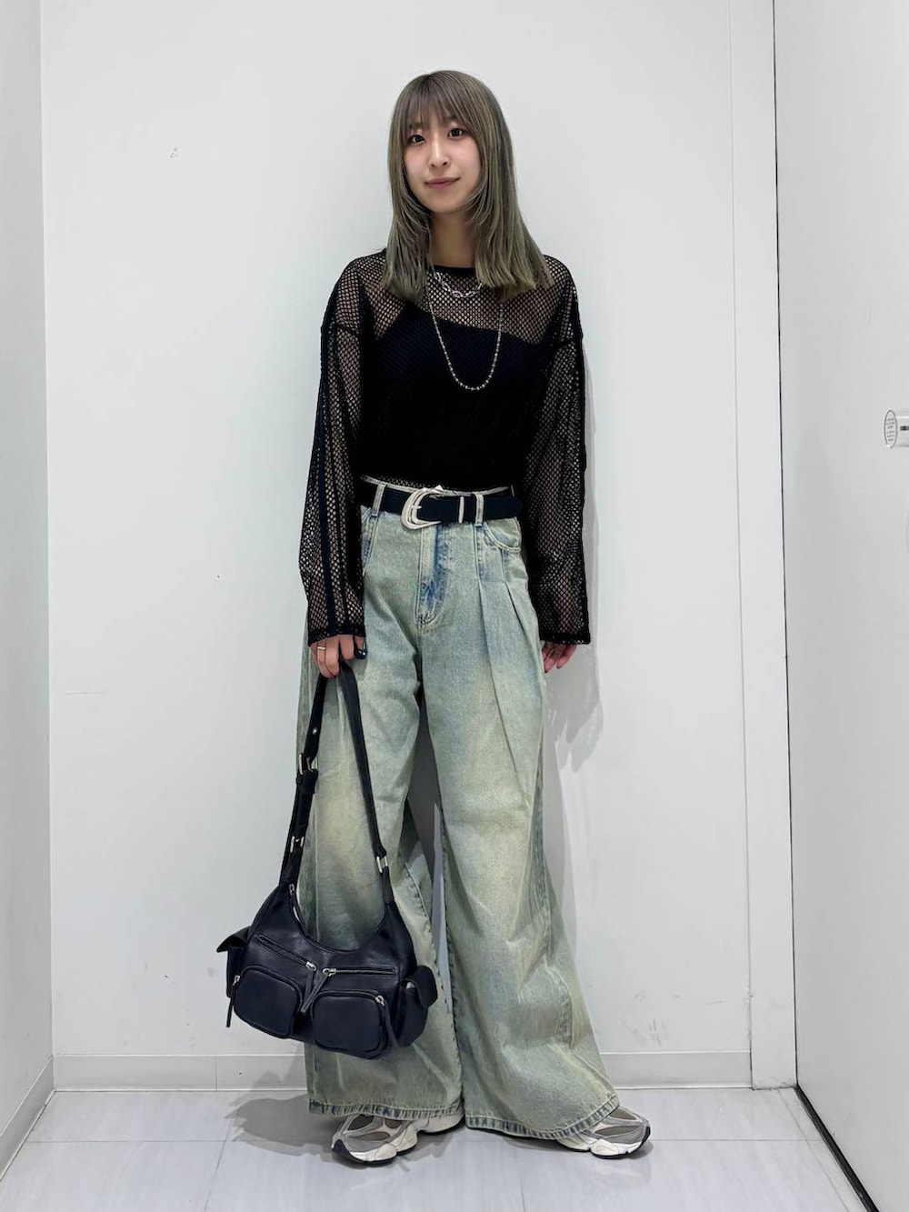 ブルー系のデニムパンツ、ブラック系のTシャツ/カットソー、ブラック系のショルダーバッグを着用したレディースの春コーディネートの6枚目の写真