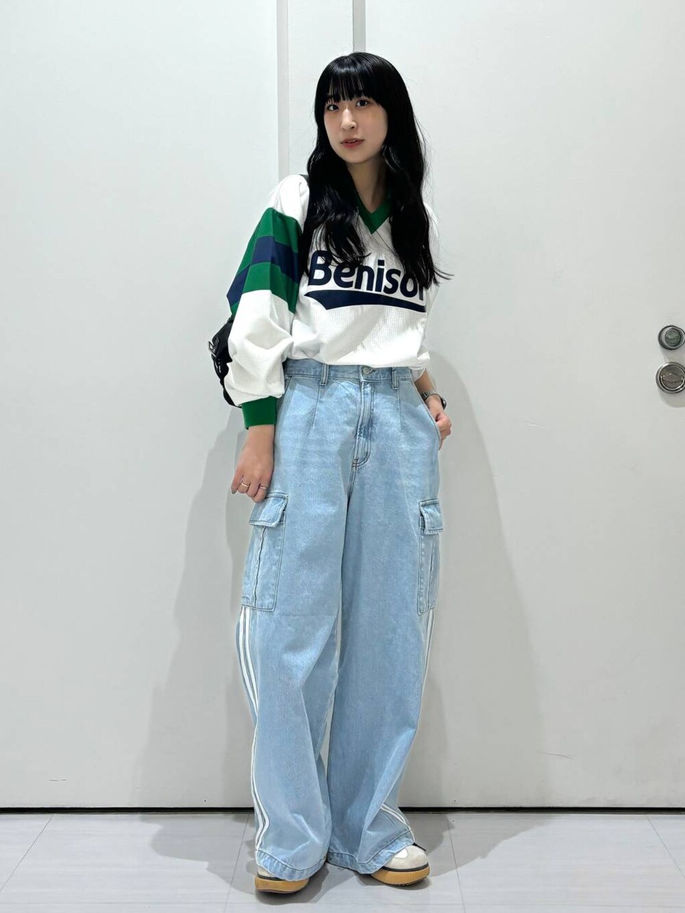 ブラック系のショルダーバッグ、ホワイト系のシャツ/ブラウス、ブルー系のデニムパンツを着用したレディースの春コーディネートの4枚目の写真