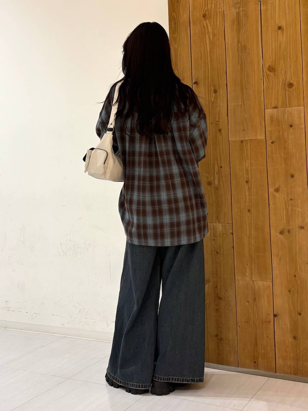 ブルー系のデニムパンツ、ホワイト系のショルダーバッグ、ブラウン系のシャツ/ブラウスを着用したレディースの冬コーディネートの3枚目の写真