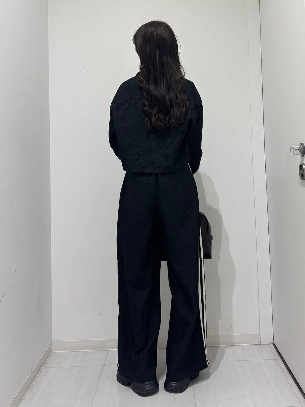 ブラック系のスニーカー、ブラック系のシャツ/ブラウス、グレー系のTシャツ/カットソーを着用したレディースの冬コーディネートの5枚目の写真