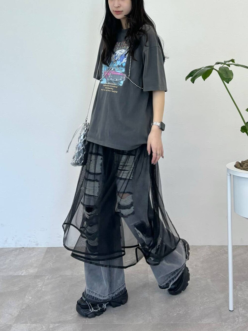 ブラック系のデニムパンツ、グレー系のTシャツ/カットソー、シルバー系のショルダーバッグを着用したレディースの春コーディネートの2枚目の写真